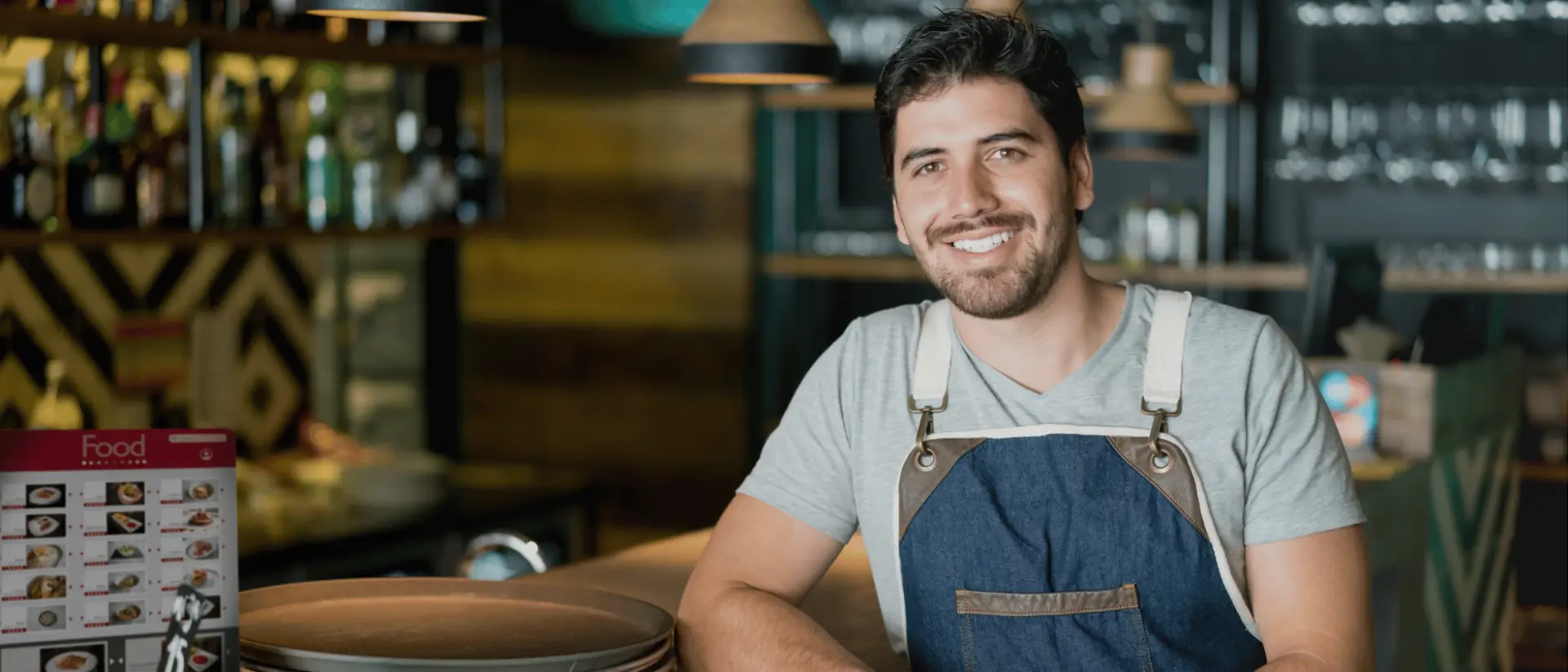 Developing Strong Entrepreneurial Businesses has a male restaurant owner smiling while leaning on his bar counter with the help of The Entrepreneurial CPA.